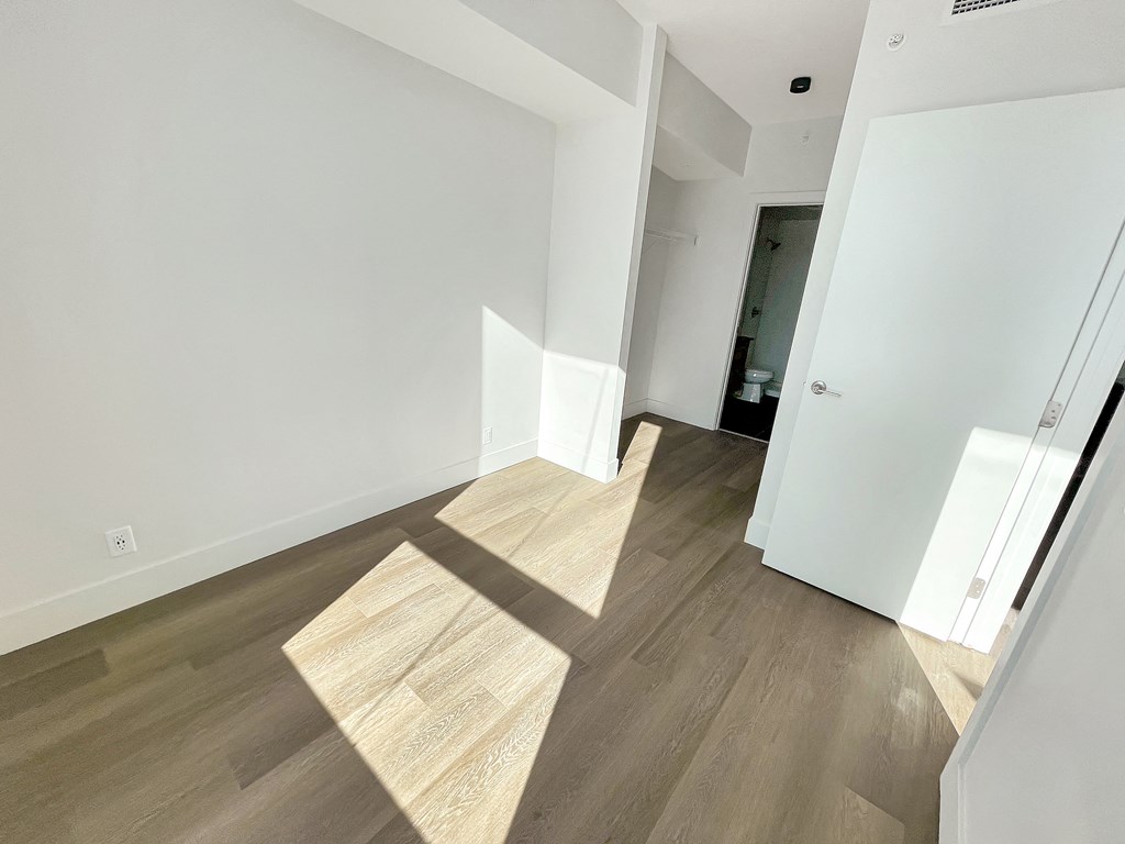 a living room with white walls and wooden floors