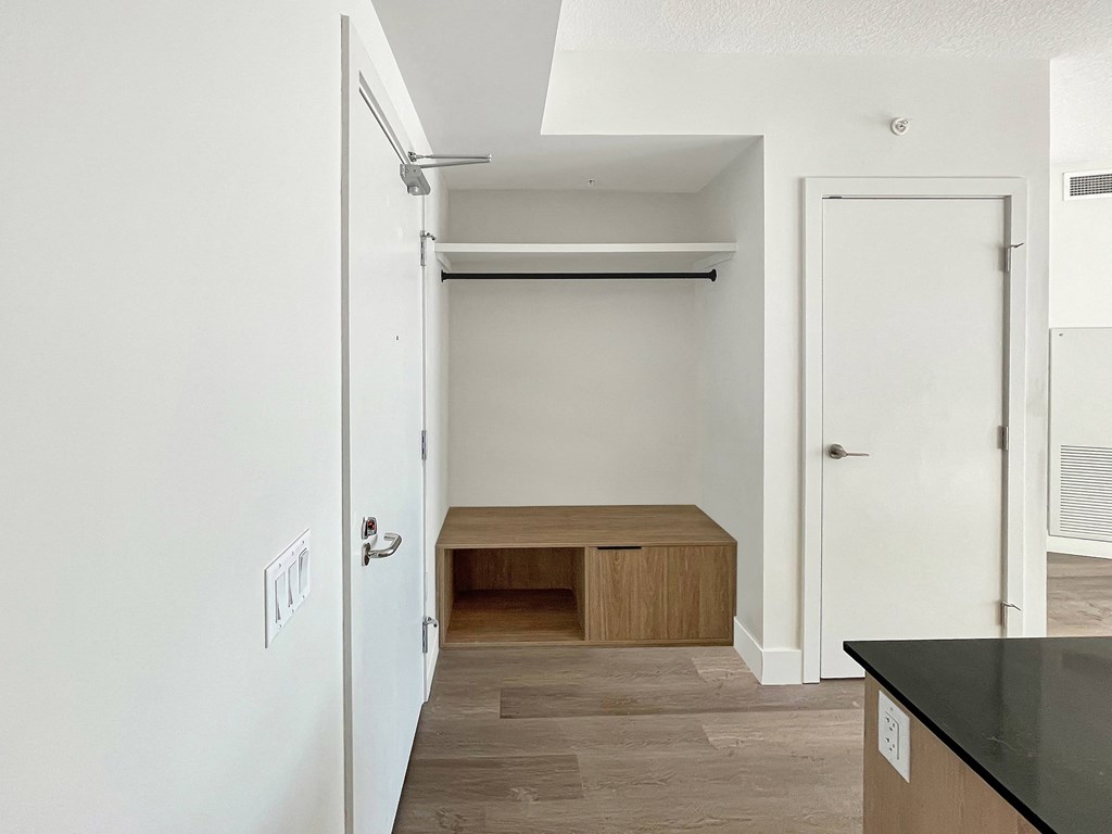 an empty hallway with a closet and a desk in a small apartment
