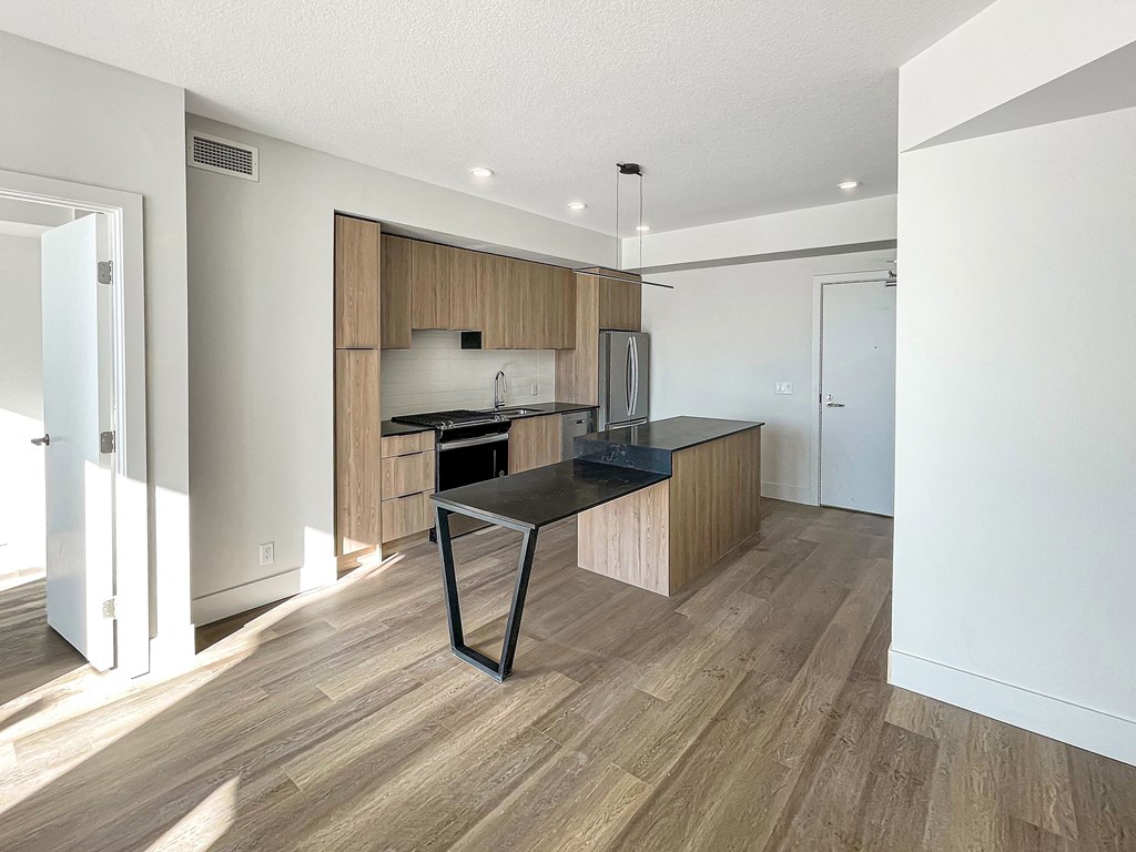 a kitchen with a black counter top and wooden cabinets
