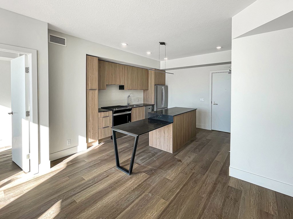 a kitchen with wooden cabinets and a black counter top