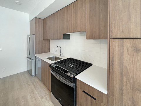 a kitchen with wooden cabinets and a stove and a sink