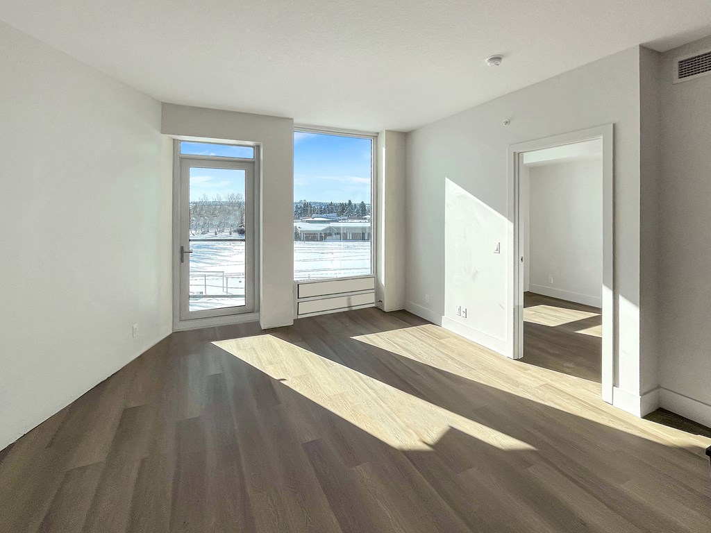 an empty living room with a view of a river in the distance