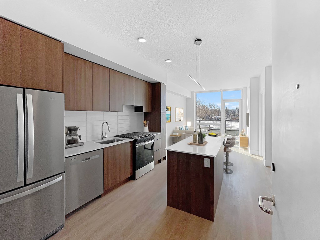 a large kitchen with stainless steel appliances and wooden cabinets