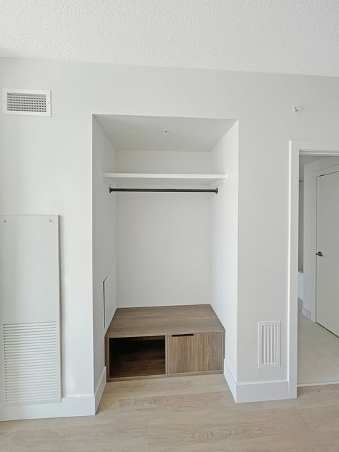 an empty hallway with a closet and a staircase in a house