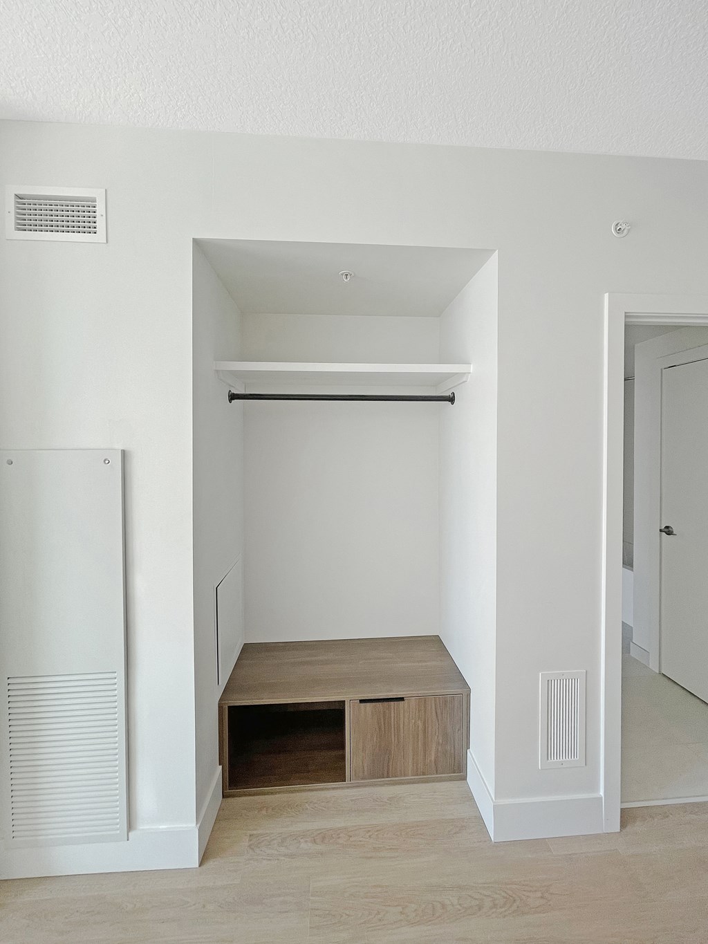 an empty hallway with a closet and a staircase in a house