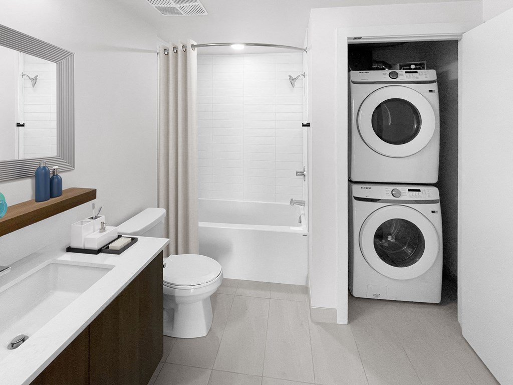 a bathroom with a washer and dryer in it and a toilet and sink