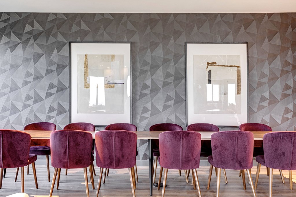 a dining room with purple chairs and a wooden table and two mirrors at Citizen on Jasper, Alberta