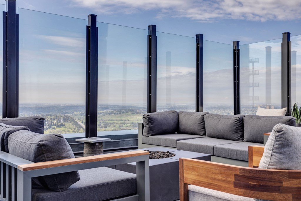 a living room with gray couches and a table with large windows at Citizen on Jasper, Alberta