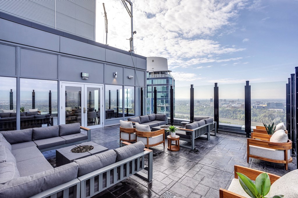 a living room with couches and tables and a view of the city at Citizen on Jasper, Alberta, T5K 0M5