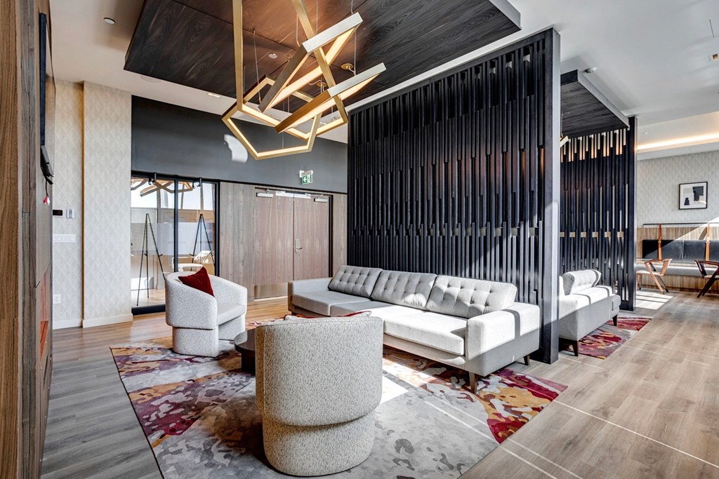 a lobby with couches chairs and a rug with a chandelier on top of it  at Citizen on Jasper, Edmonton, AB, T5K 0M5