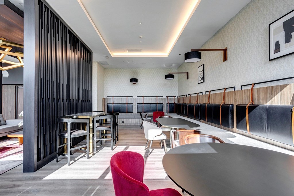 a room with tables and chairs and a wall with wooden dividers  at Citizen on Jasper, Edmonton, Alberta
