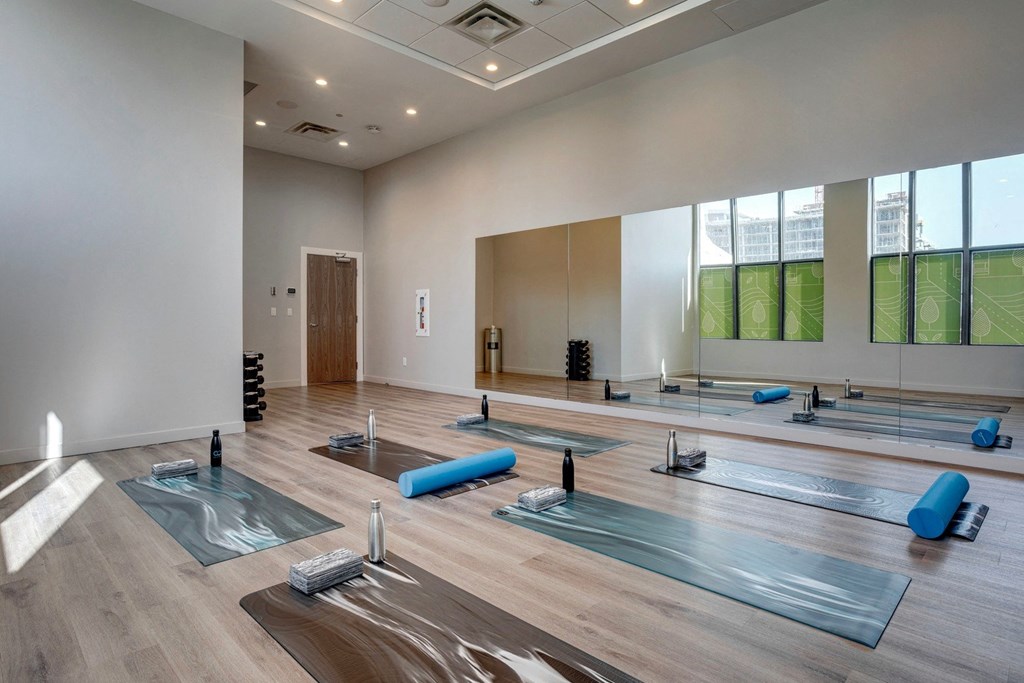 a spacious yoga studio with large windows and wood floors  at Citizen on Jasper, Edmonton