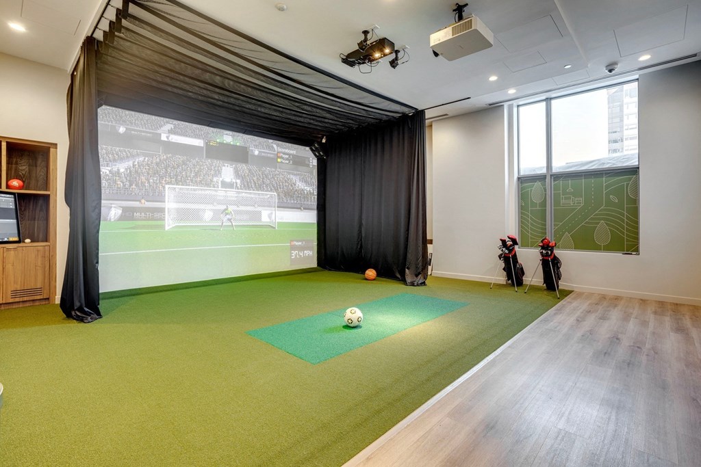 a room with a projector screen and a soccer game on the wall  at Citizen on Jasper, Edmonton, T5K 0M5
