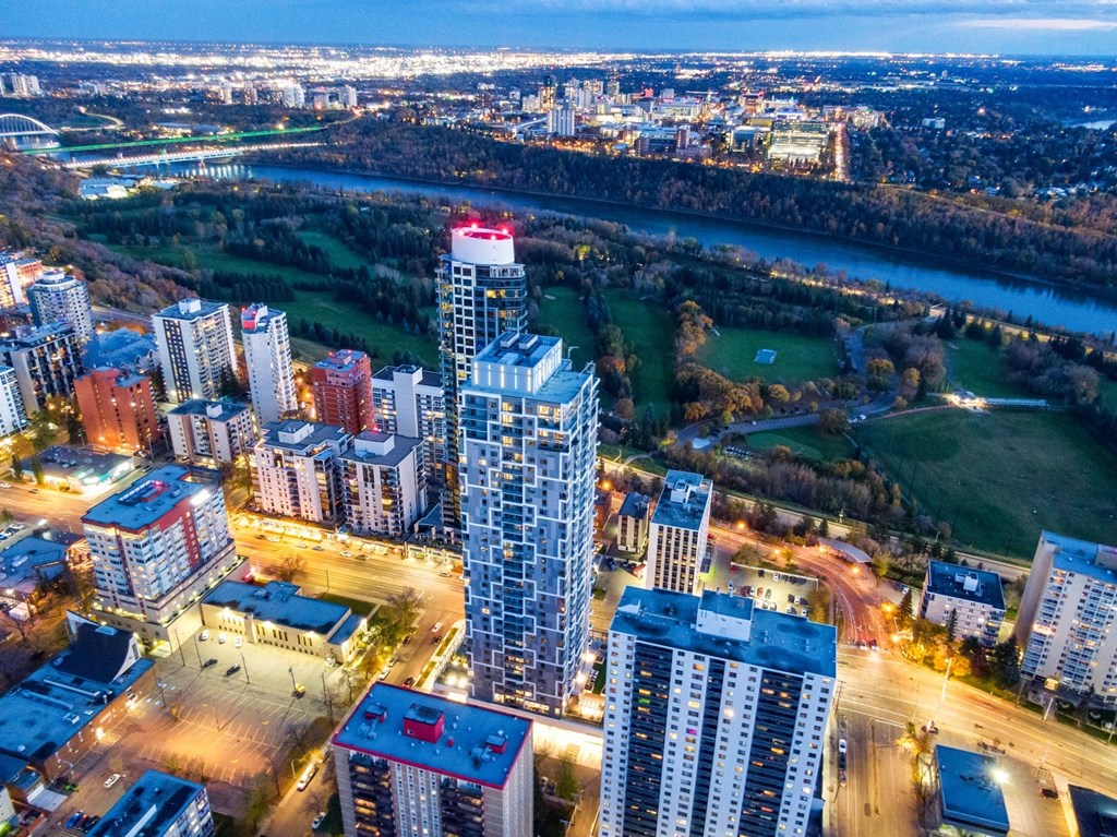 an aerial view of a city at night with buildings and a river