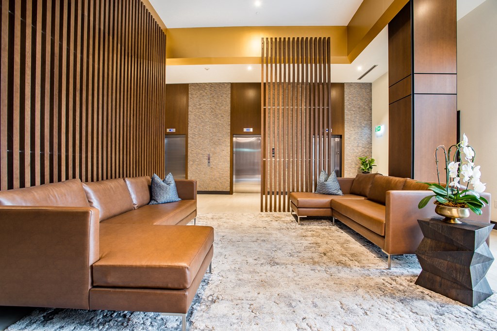 a lobby with brown couches and a white rug at The Village, Ontario, L6L 0H1