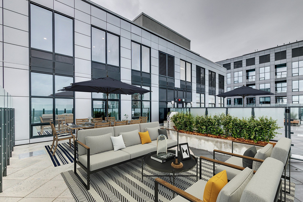 a terrace with couches and chairs and a table with umbrellas at BLVD Beltline, Calgary, AB