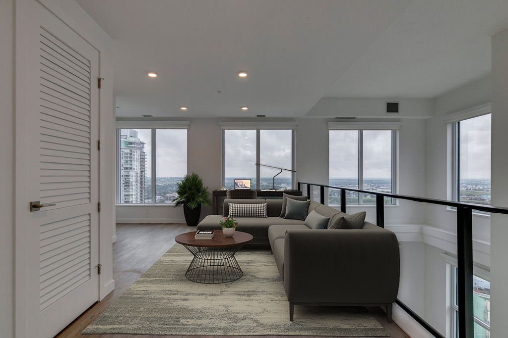 a living room with a couch and a coffee table in front of windows at BLVD Beltline, Calgary, AB