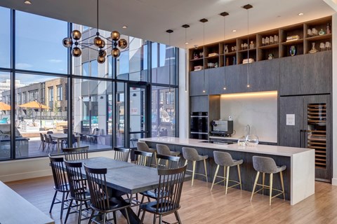 a dining room with a table and chairs and a kitchen with large windows