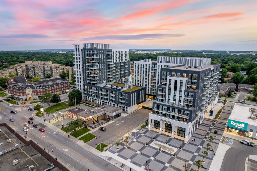 an aerial view of a city with tall buildings and a sunset at The Village, Oakville, ON