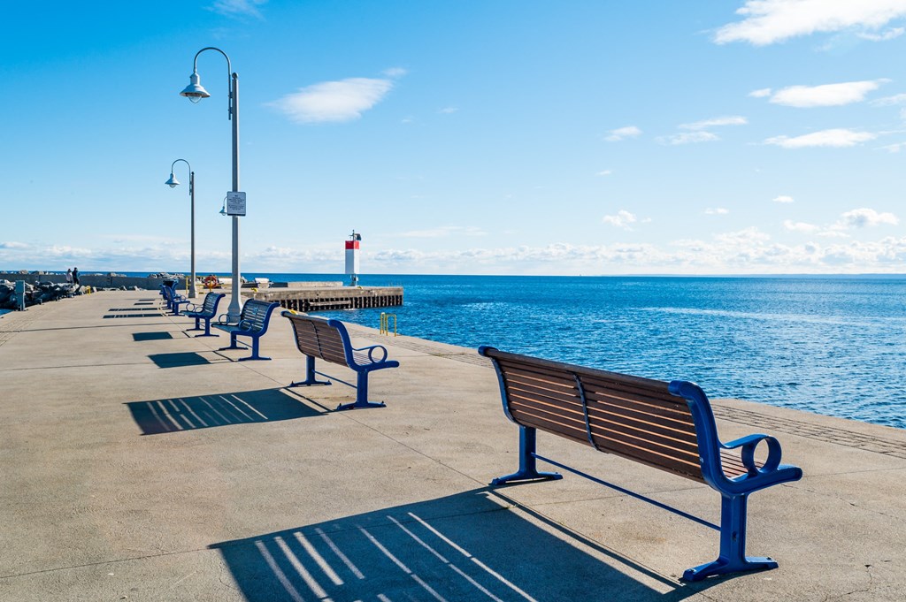 a row of benches on a pier overlooking the ocean at The Village, Oakville, L6L 0H1