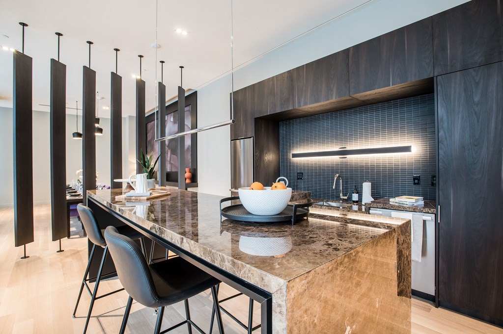 a kitchen with a large island with chairs and a sink at The Village, Ontario, L6L 0H1
