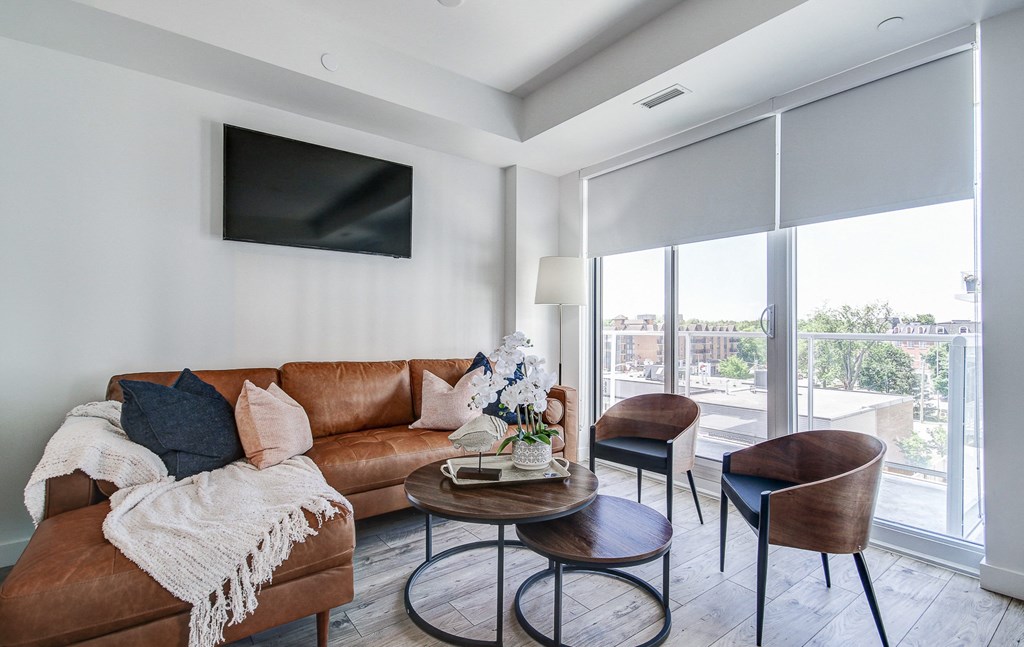 a living room with a leather couch and a table with two chairs at The Village, Oakville, L6L 0H1