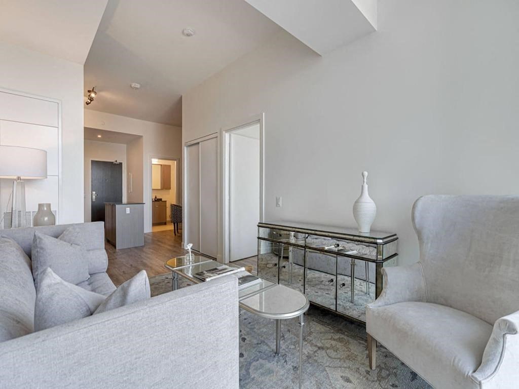 a living room with a couch and a glass table at The Village, Oakville