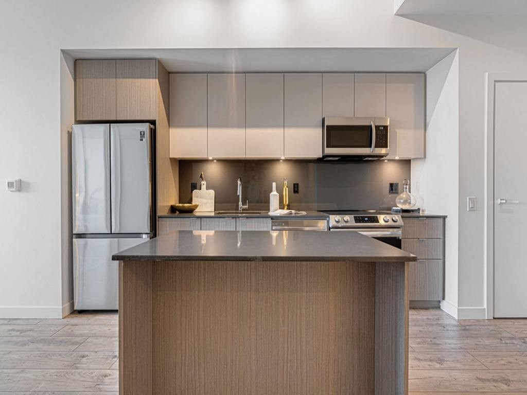 a kitchen with a counter top and a refrigerator at The Village, Ontario