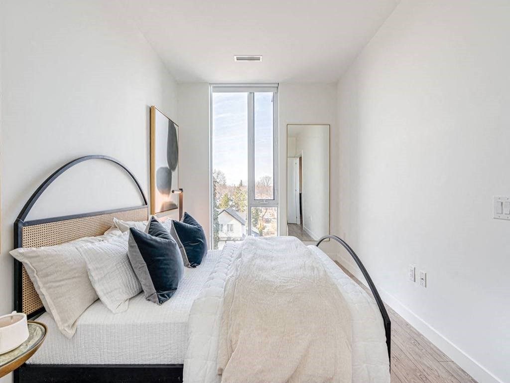 a bedroom with a bed with pillows and a window at The Village, Oakville, ON