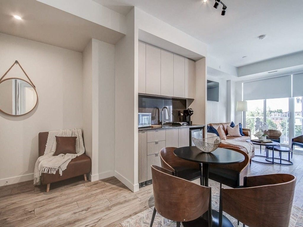 a living room and a kitchen with a table and chairs at The Village, Oakville