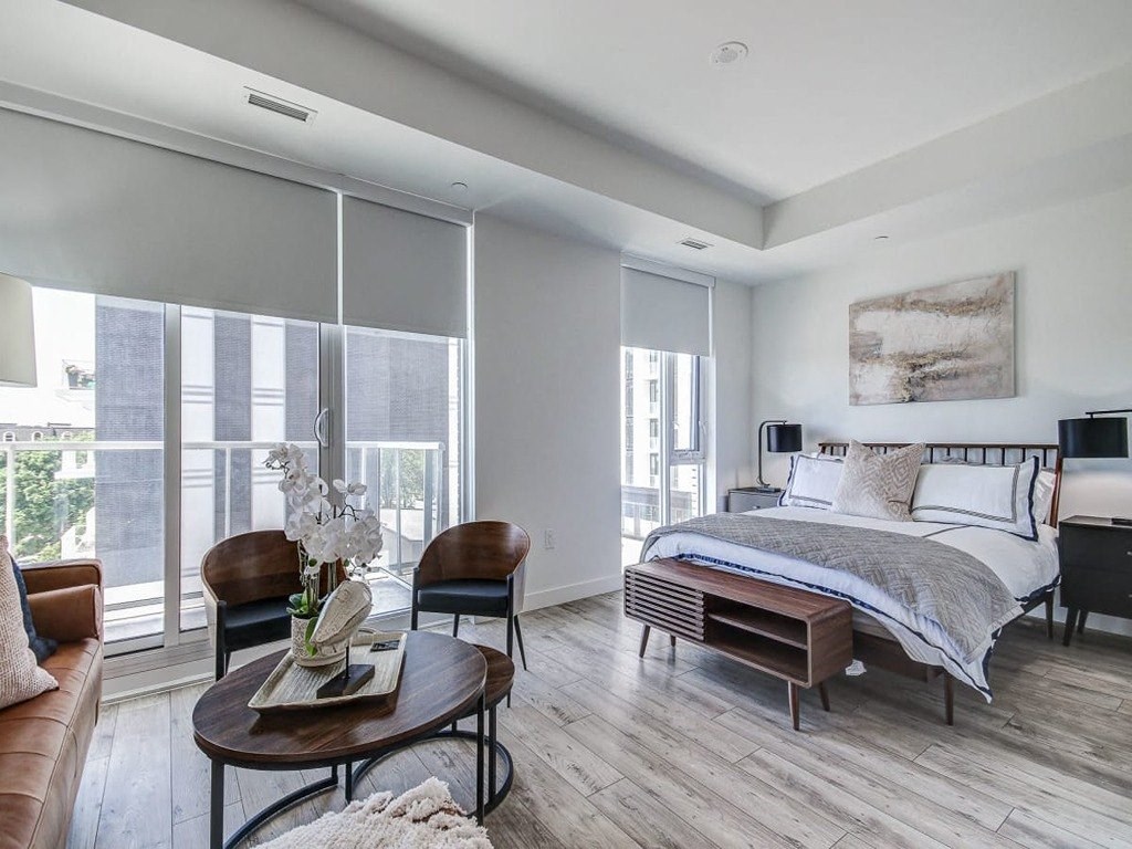 a bedroom with a bed and a large window at The Village, Ontario