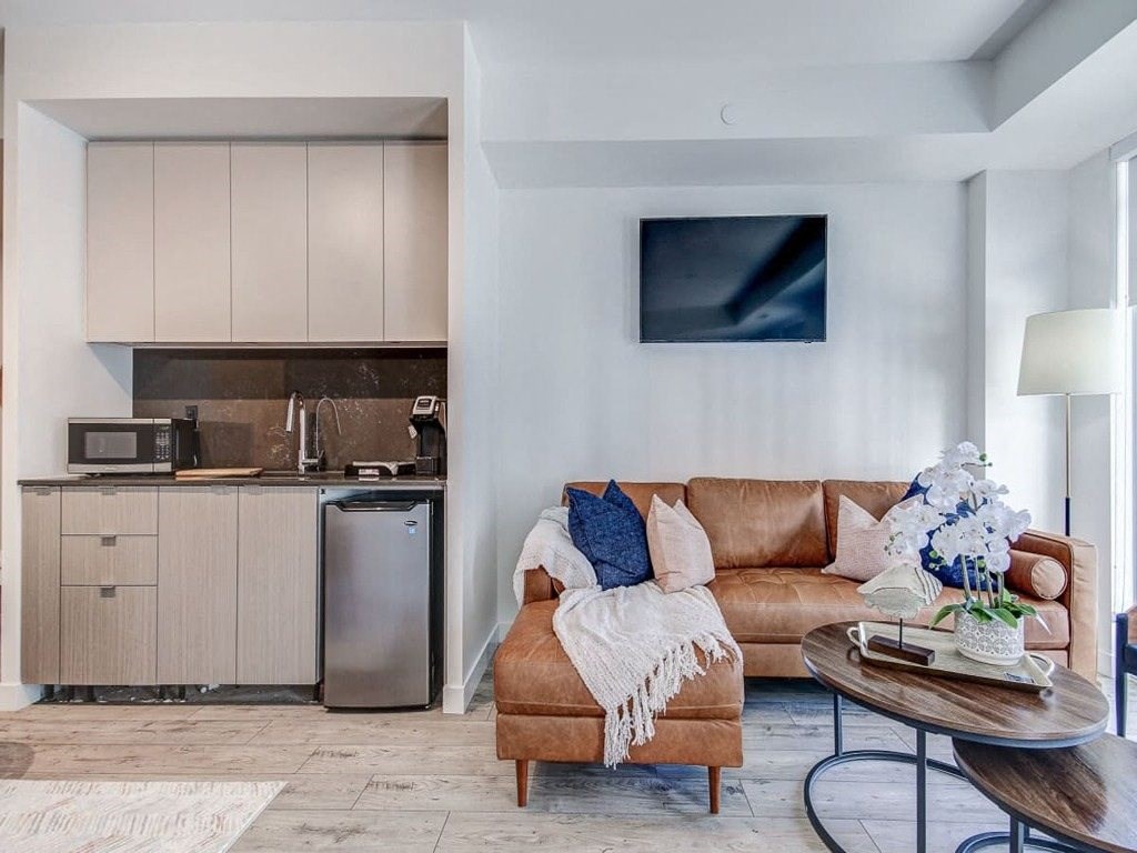 a living room with a couch and a table  at The Village, Oakville, ON