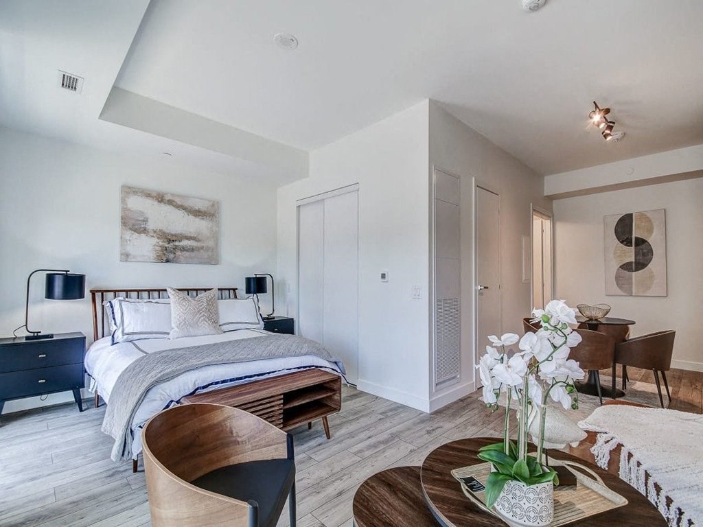 a bedroom with a bed and a table with a vase of flowers at The Village, Ontario, L6L 0H1