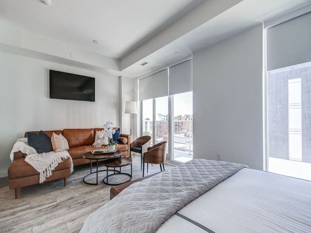 a bedroom and living room with a couch and a bed  at The Village, Oakville, ON, L6L 0H1