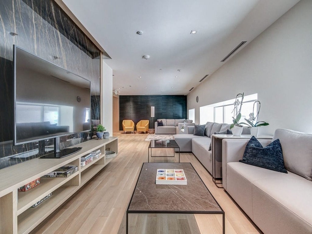 a living room with a couch and a television  at The Village, Oakville