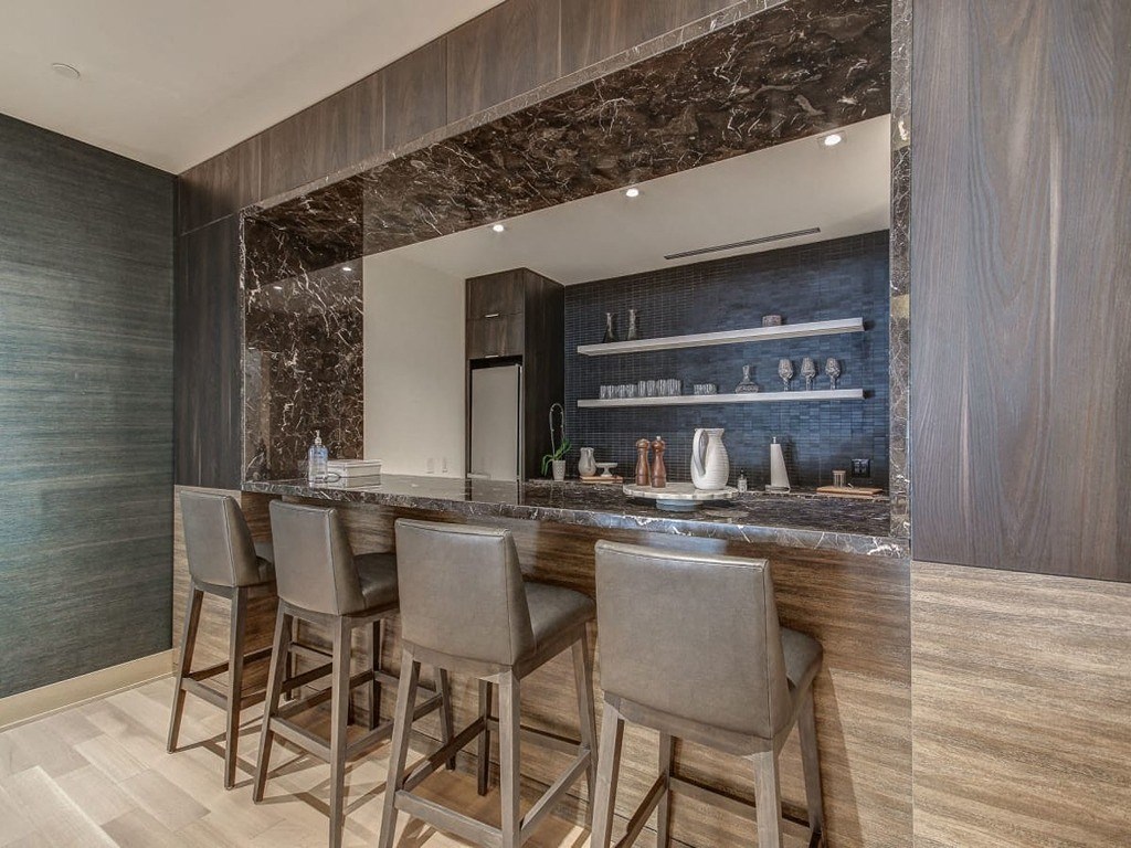 a bar with bar stools in front of a wall with a geometric design  at The Village, Oakville