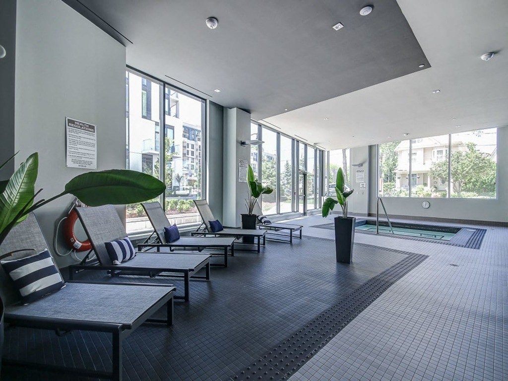 a large lobby with chairs and a pool in a building at The Village, Ontario, L6L 0H1