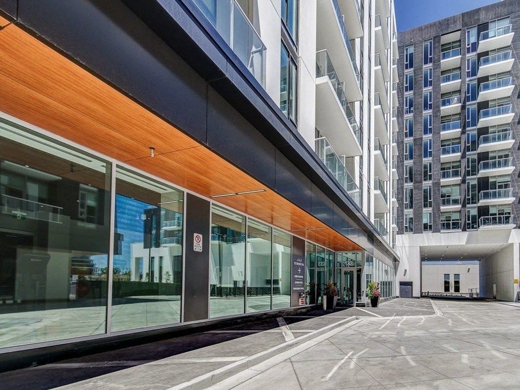 the side of a building with large glass windows and a courtyard  at The Village, Oakville, ON, L6L 0H1