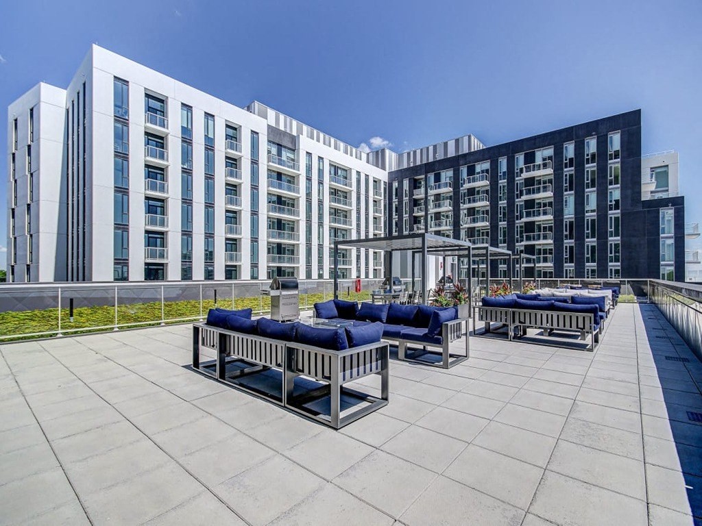 a rooftop patio with benches and chairs in front of a building at The Village, Oakville, ON, L6L 0H1