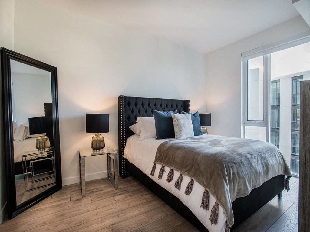 a bedroom with a bed and a large mirror at The Village, Oakville, ON, L6L 0H1