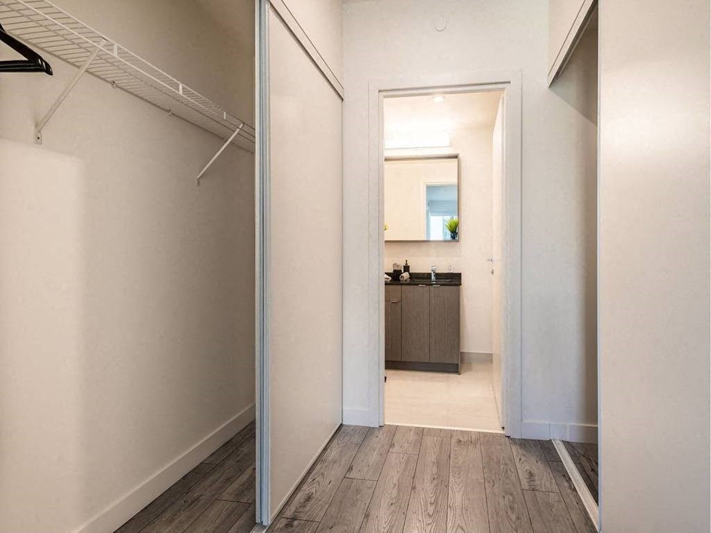 a hallway with a closet and a bathroom with a mirror  at The Village, Oakville, ON