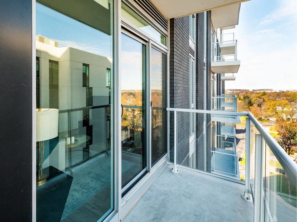 a balcony with sliding glass doors and a view of the city at The Village, Ontario, L6L 0H1