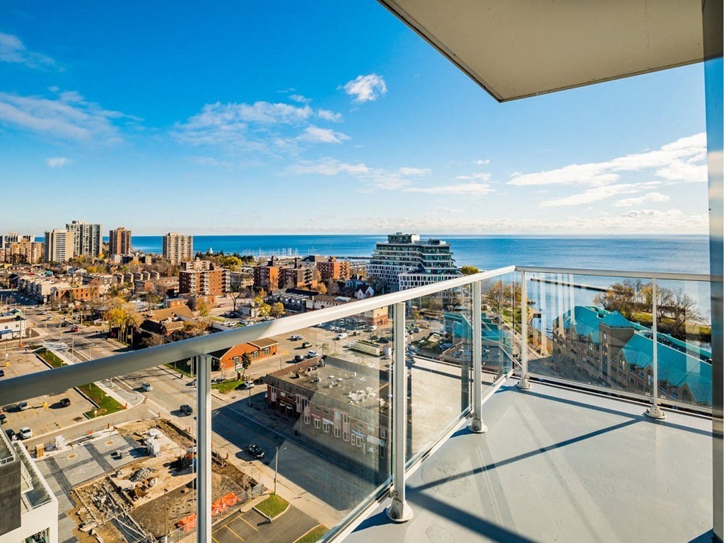 a balcony with a view of a city and the ocean at The Village, Oakville, ON
