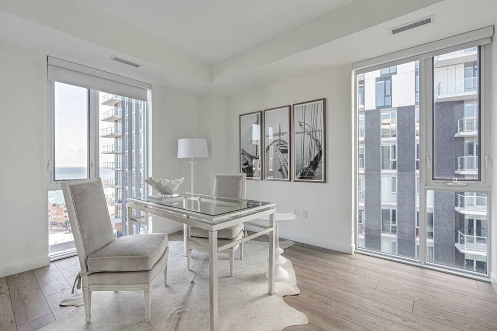 a living room with a glass desk and a large window