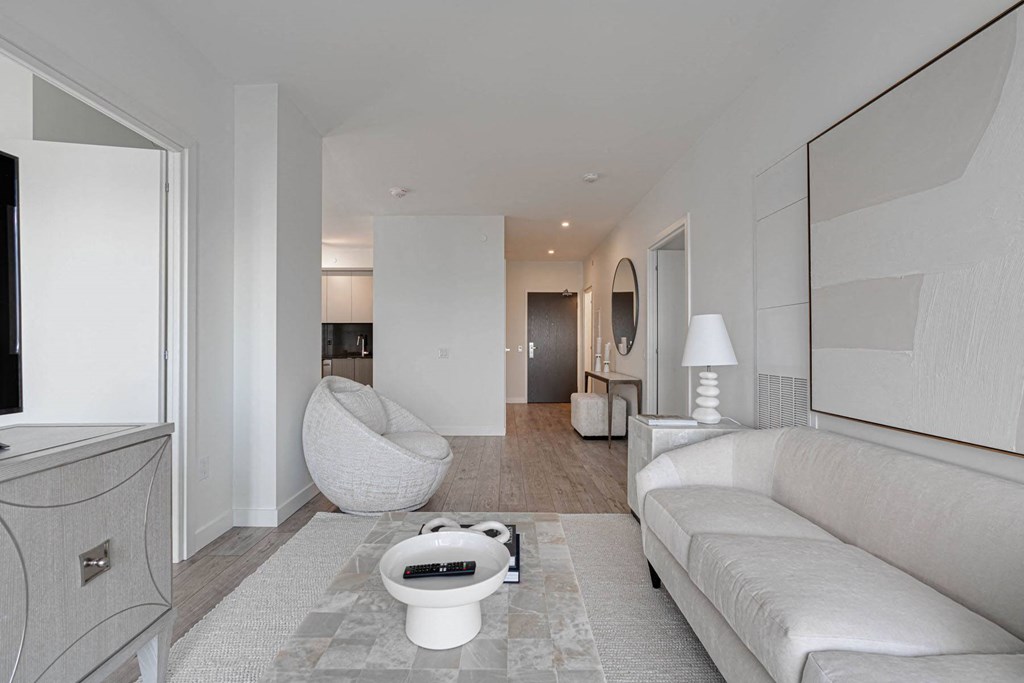 a white living room with a large white couch and a white bathroom