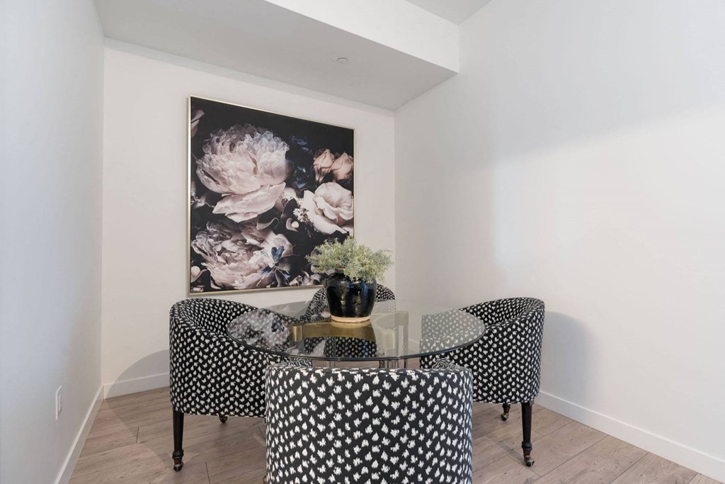 a dining room with a table and chairs and a painting on the wall