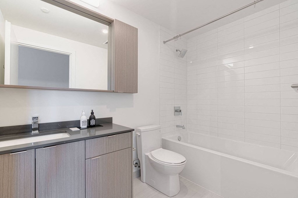 a bathroom with a toilet and a sink and a bath tub
