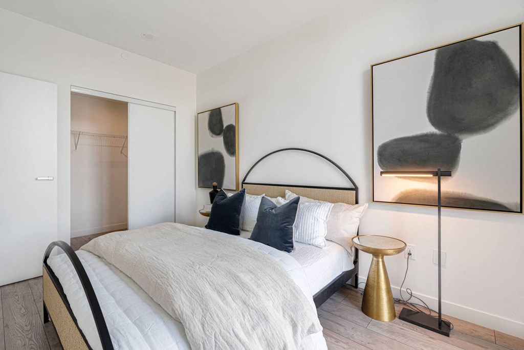 a bedroom with a bed and a chair and a mirror