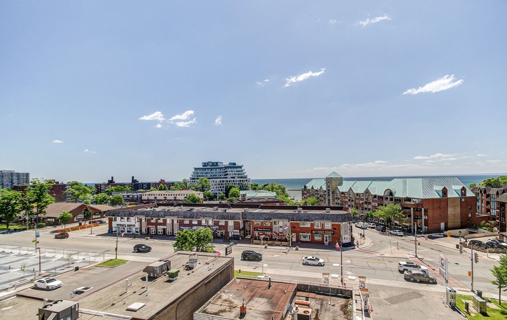 an aerial view of a city street with buildings and the ocean in the background