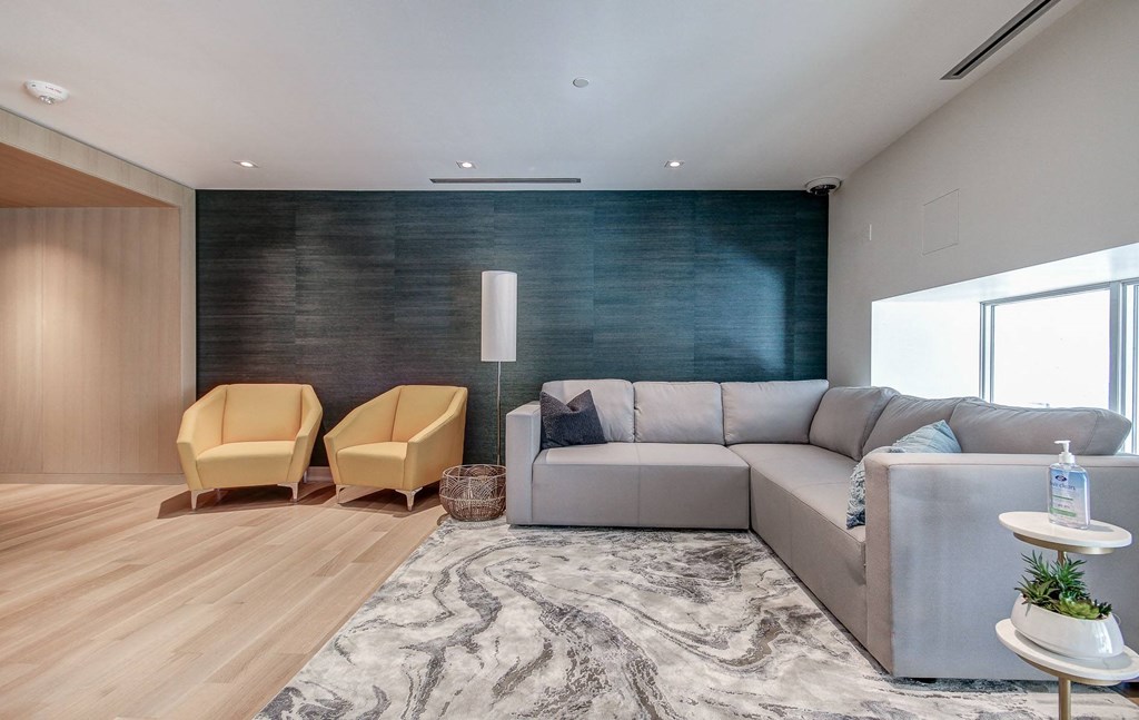 a living room with a gray couch and two yellow chairs